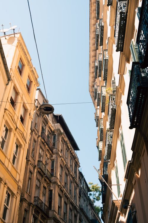 Free Low-angle view of historic buildings in a sunny urban setting, showcasing architectural details. Stock Photo