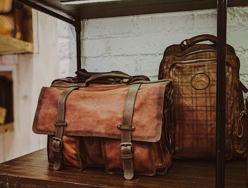 Free Brown Leather 2 Way Bag on Brown Wooden Table Stock Photo