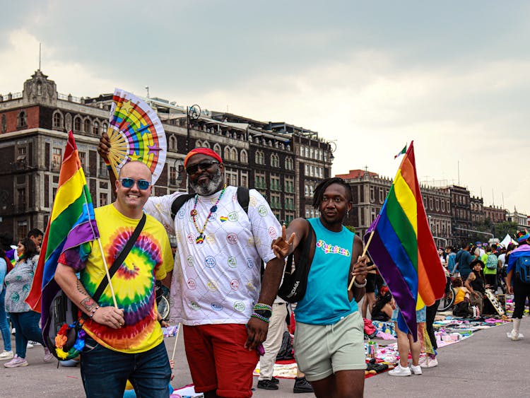 People Walking On Street With Rainbow Flags