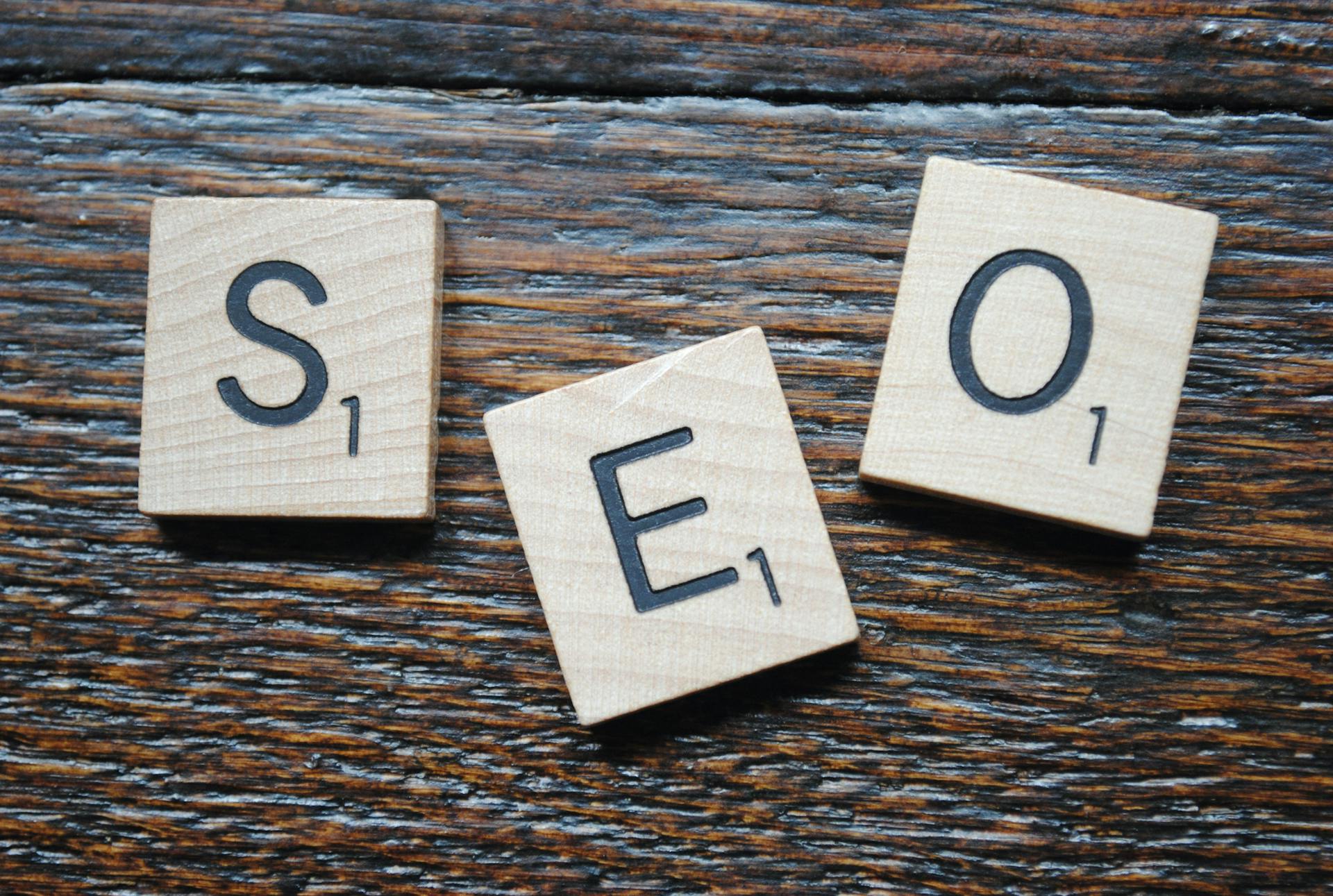 Close-up of Scrabble tiles spelling SEO on a wooden table for content strategy.