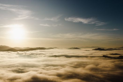 A breathtaking aerial view of low-lying clouds over a mountain range in São Paulo during sunrise.