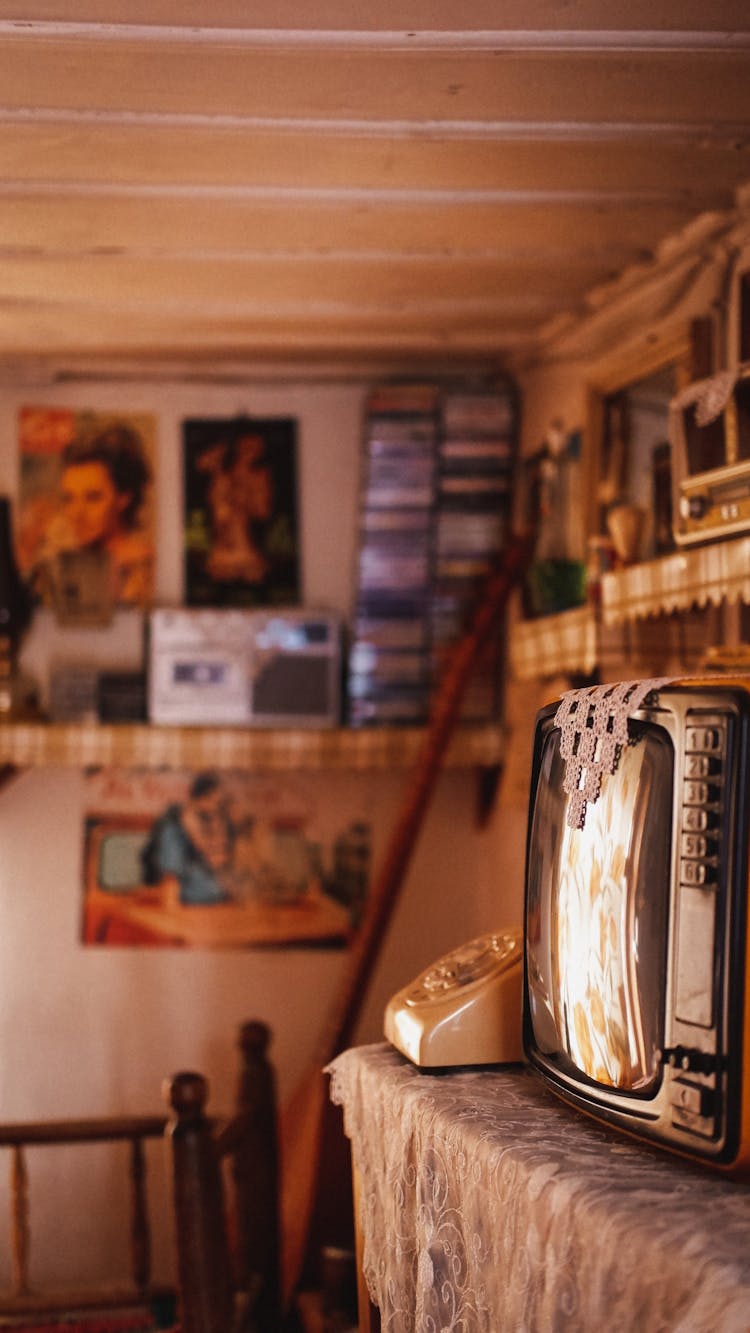 Photo Of A Room With A Old Telephone, A Televison, A Radio And A CD Collection