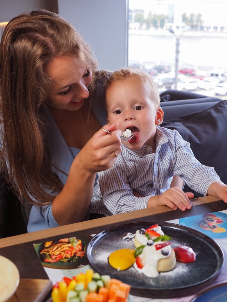 Woman Feeding Child At Home