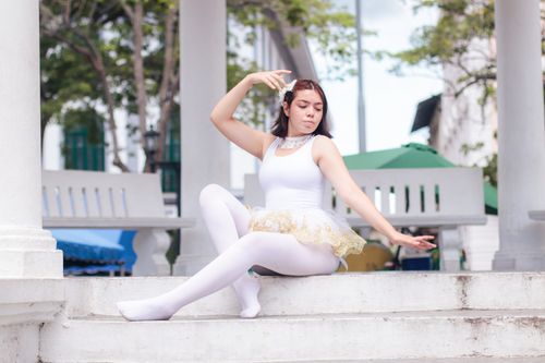 Free Elegant ballerina posing in a tutu on outdoor steps, captured in natural light. Stock Photo