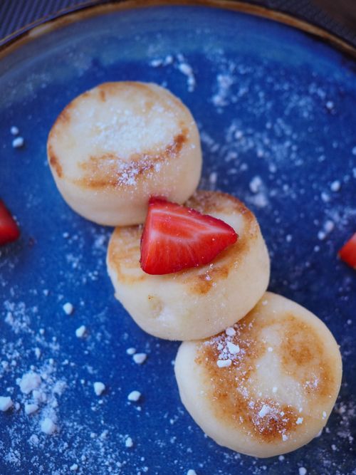 Free Delicious soft pastries topped with fresh strawberries on a blue plate. Perfect for dessert lovers. Stock Photo