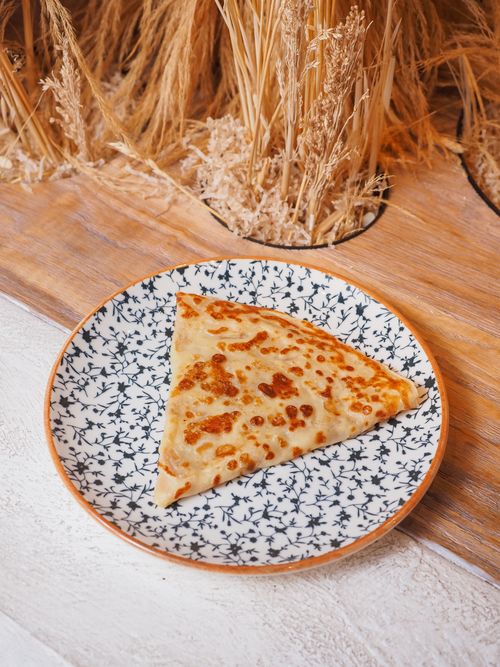 Free Delicious crepe served on a floral plate, perfect for a rustic breakfast setup. Stock Photo