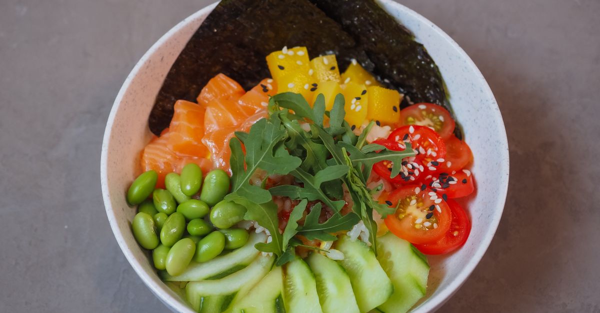 a bowl of wakame seaweed salad with sesame seeds and cucumber slices