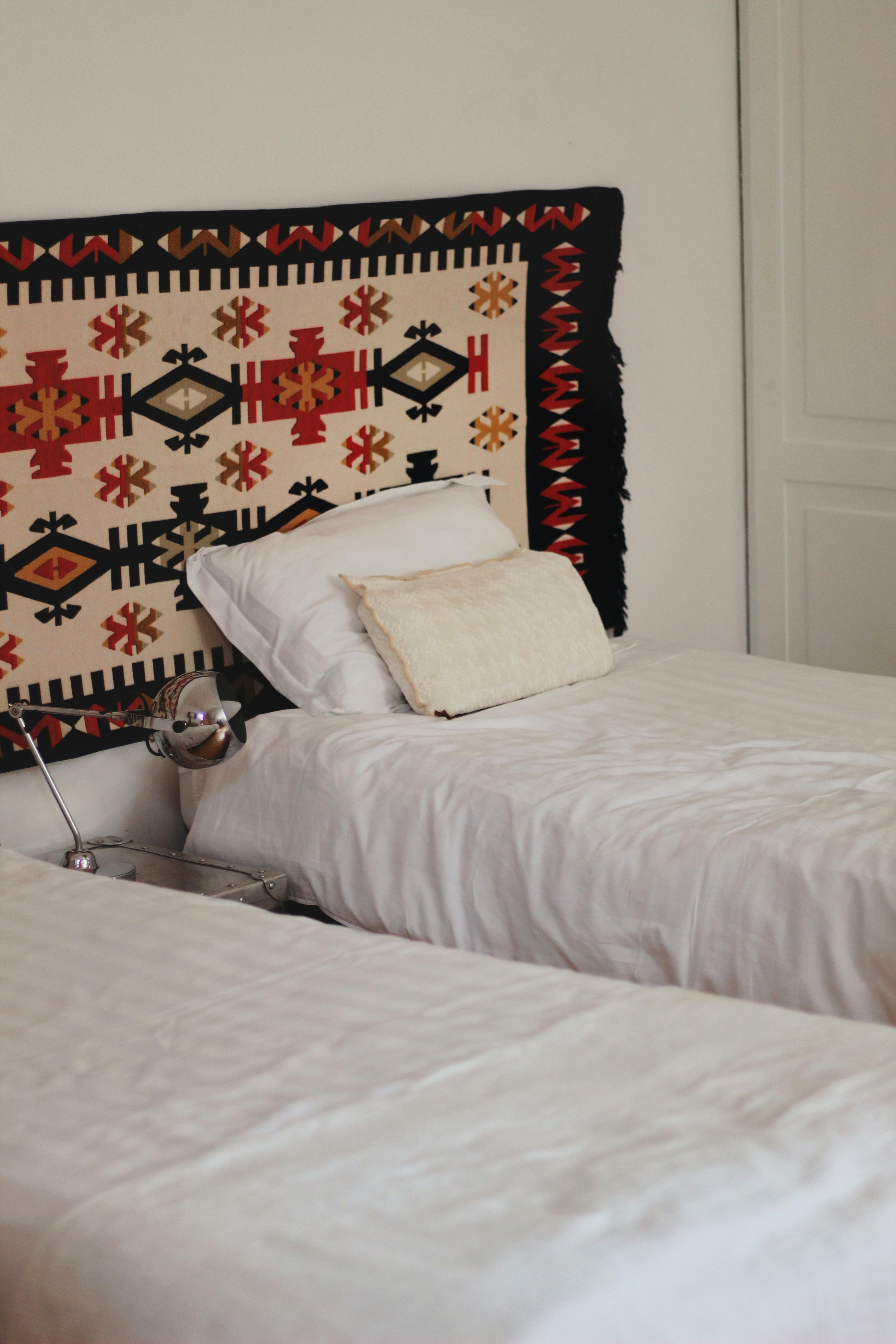 Stylish twin bedroom featuring a traditional tapestry. Perfect for hotel or home interiors.
