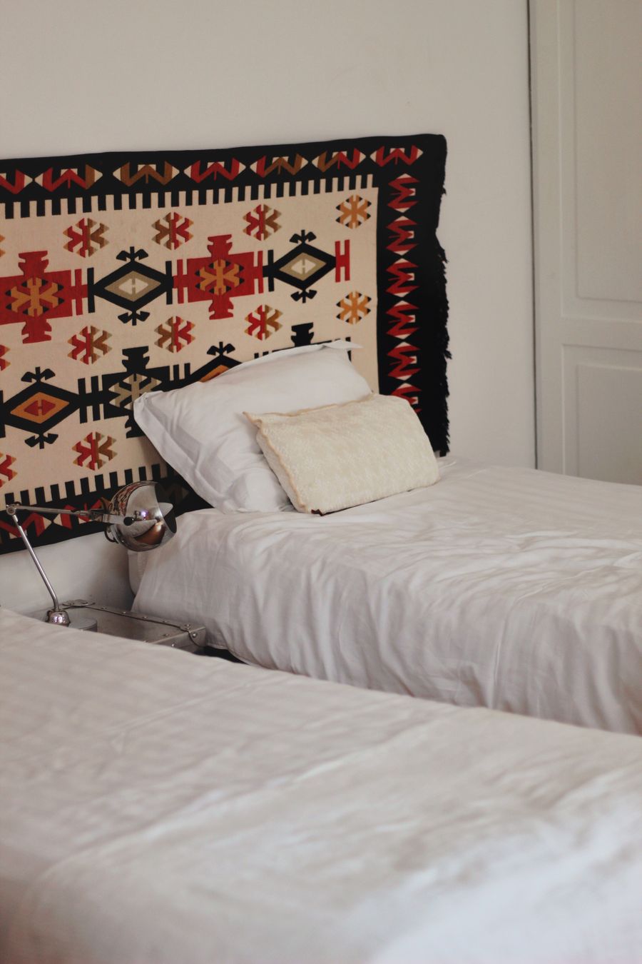 Twin hotel room with two made beds and warm decor