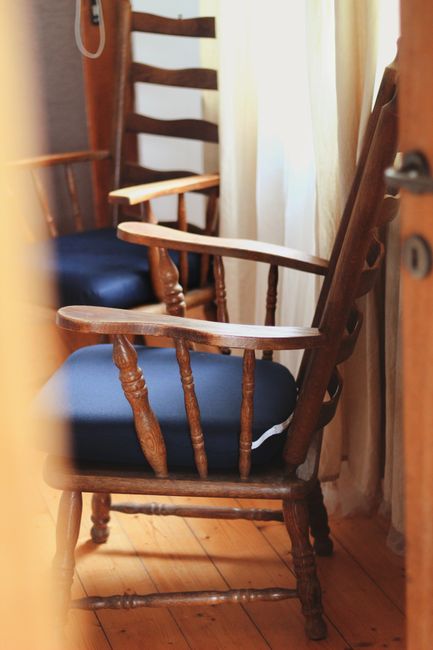 Fotomural Dos cómodas sillas de madera con cojines azules en un ambiente interior tranquilo.