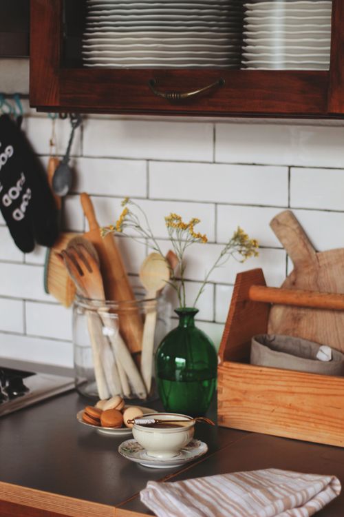 Free Warm kitchen countertop with plates, utensils, and a green vase creating a cozy cooking environment. Stock Photo