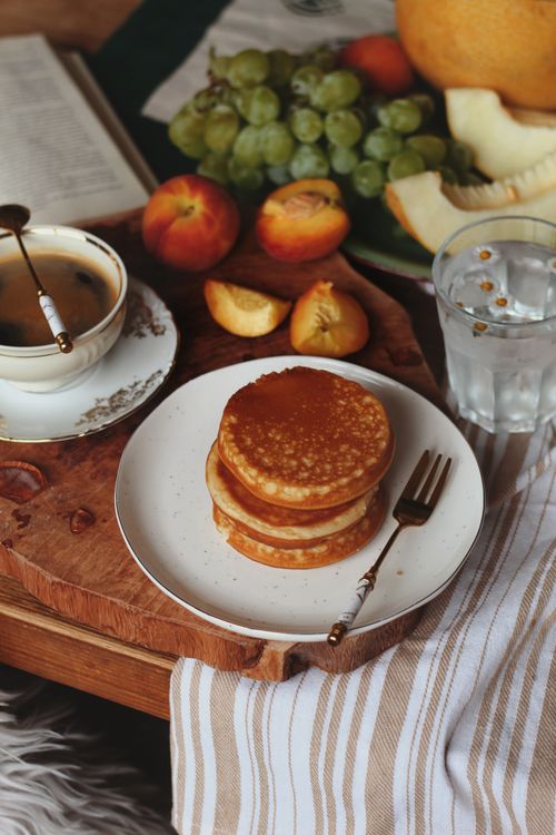 Free Rustic breakfast with pancakes, coffee, and fresh fruits on a wooden table. Stock Photo
