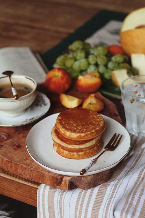 Free Delightful breakfast scene with pancakes and fresh fruit on a wooden table. Stock Photo