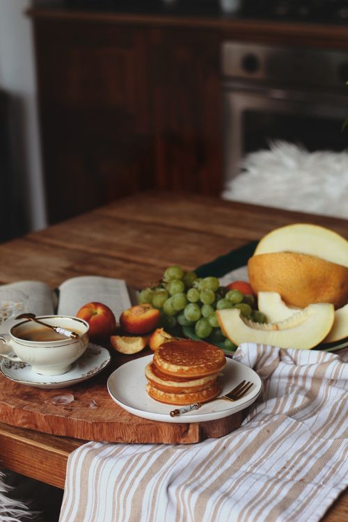 Free Delicious breakfast spread with pancakes, fruit, and coffee on a cozy table setting. Stock Photo