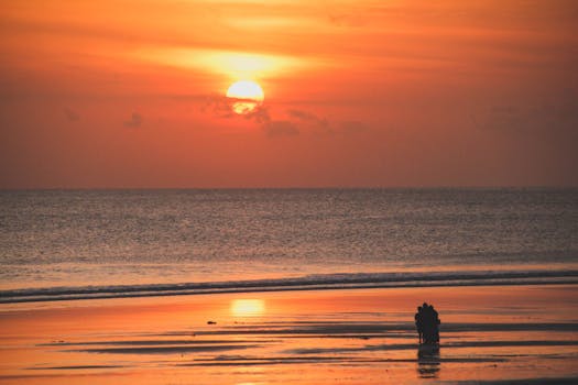 Silhouette of a couple at sunset on Kuta Beach, Bali. Scenic and serene.