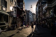 黄昏时分，城市的一条街道熙熙攘攘，行人往来，建筑风格多样