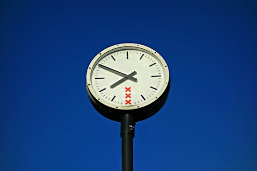 Free White and Black Round Top Analog Pedestal Clock Low Angle View Stock Photo