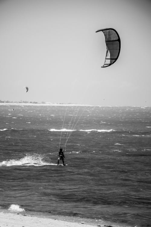 Black and White Photo of a Person Kitesurfing 