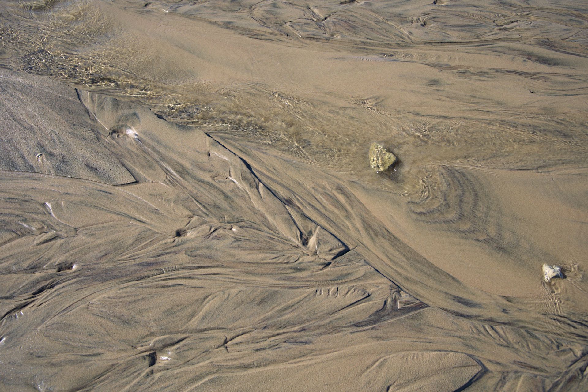 Intricate natural sand patterns and textures at Port Elgin Beach, Ontario, showcasing flowing water effects.
