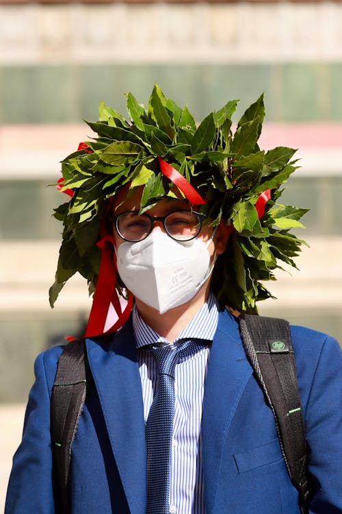 A Person in a Suit Wearing a Crown of Leaves