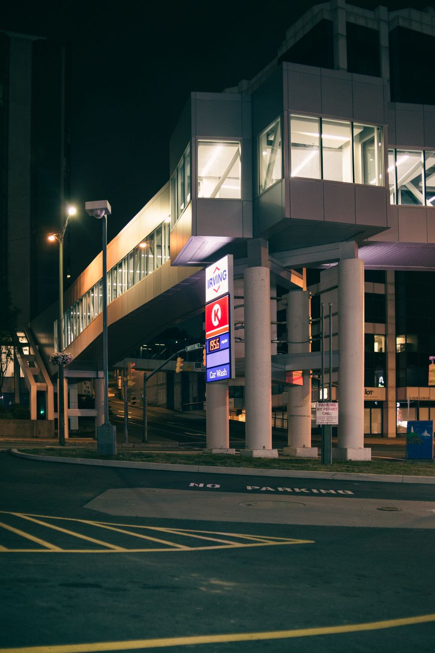 A modern urban building exterior illuminated at night, showcasing contemporary architectural design.