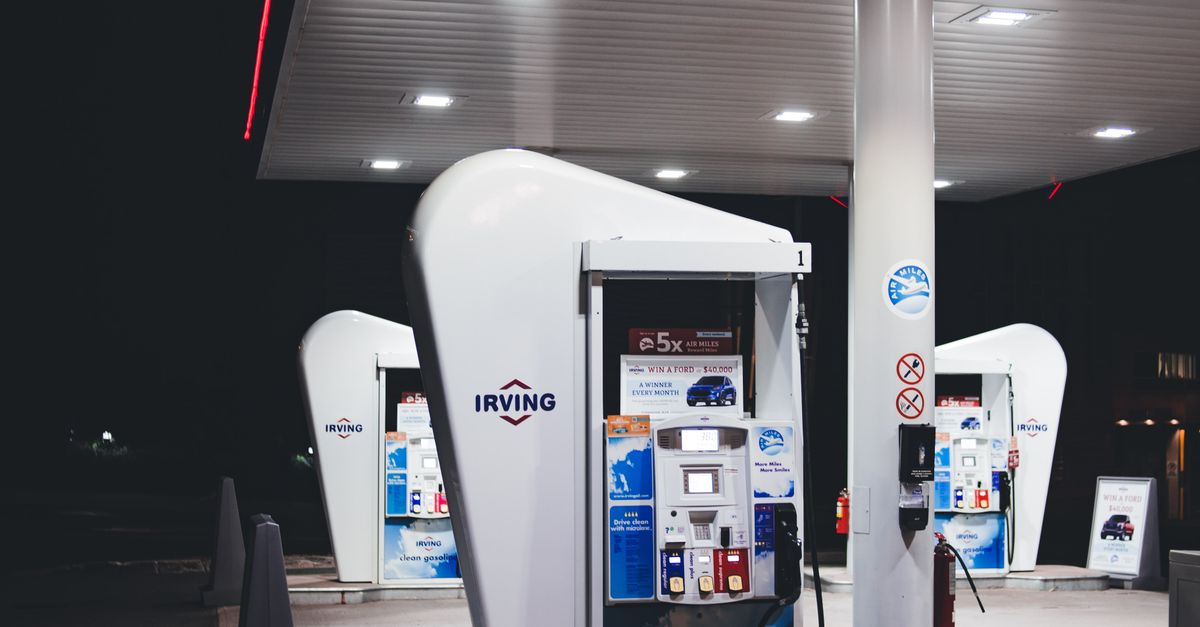 Photo by Erik Mclean Nighttime view of a modern gas station with bright lights and fuel pumps. Ideal for urban or travel themes.