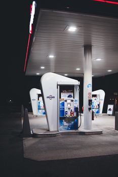 Photo by Erik Mclean Nighttime view of a modern gas station with bright lights and fuel pumps. Ideal for urban or travel themes.