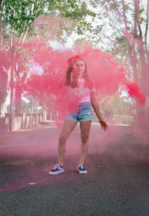 Woman Holding a Smoke Bomb on the Street