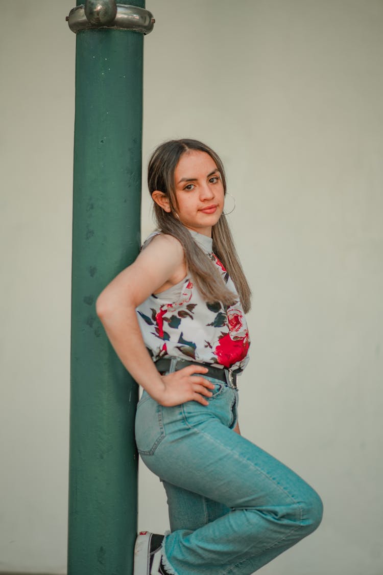 Woman In Floral Top Leaning On Post