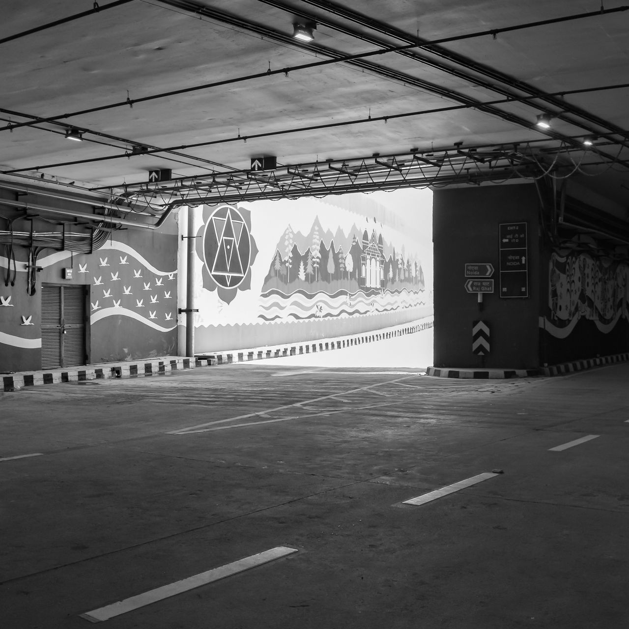 black and white image of an urban parking lot with vibrant street art