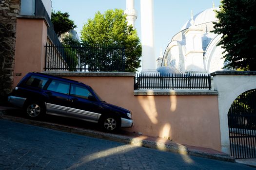 A car parked on a steep incline near Suleymaniye Mosque in Istanbul, showcasing urban architecture.