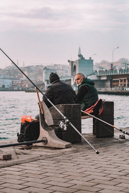 Men Sitting on Concrete Bench while Having Conversation