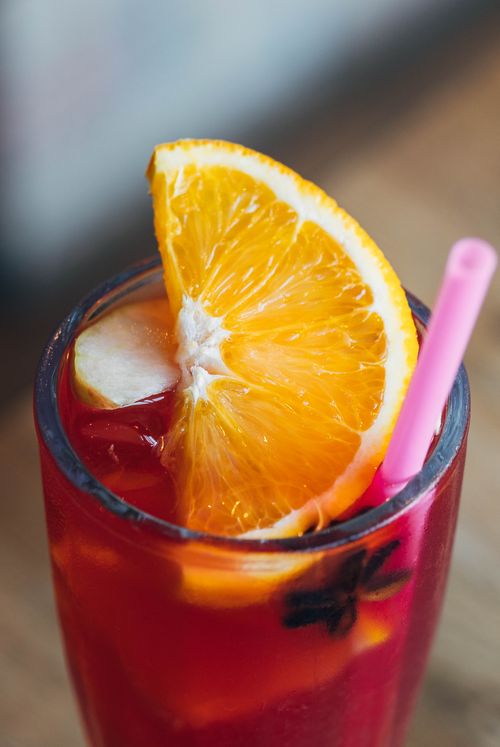 Free Close-up of a vibrant citrus cocktail garnished with an orange slice, perfect for summer refreshment. Stock Photo