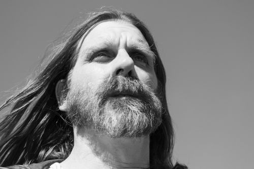 Free A striking black and white close-up portrait of a bearded man with long hair. Stock Photo