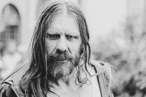 Free Close-up black and white portrait of a bearded man with long hair, depicting strong emotion. Stock Photo
