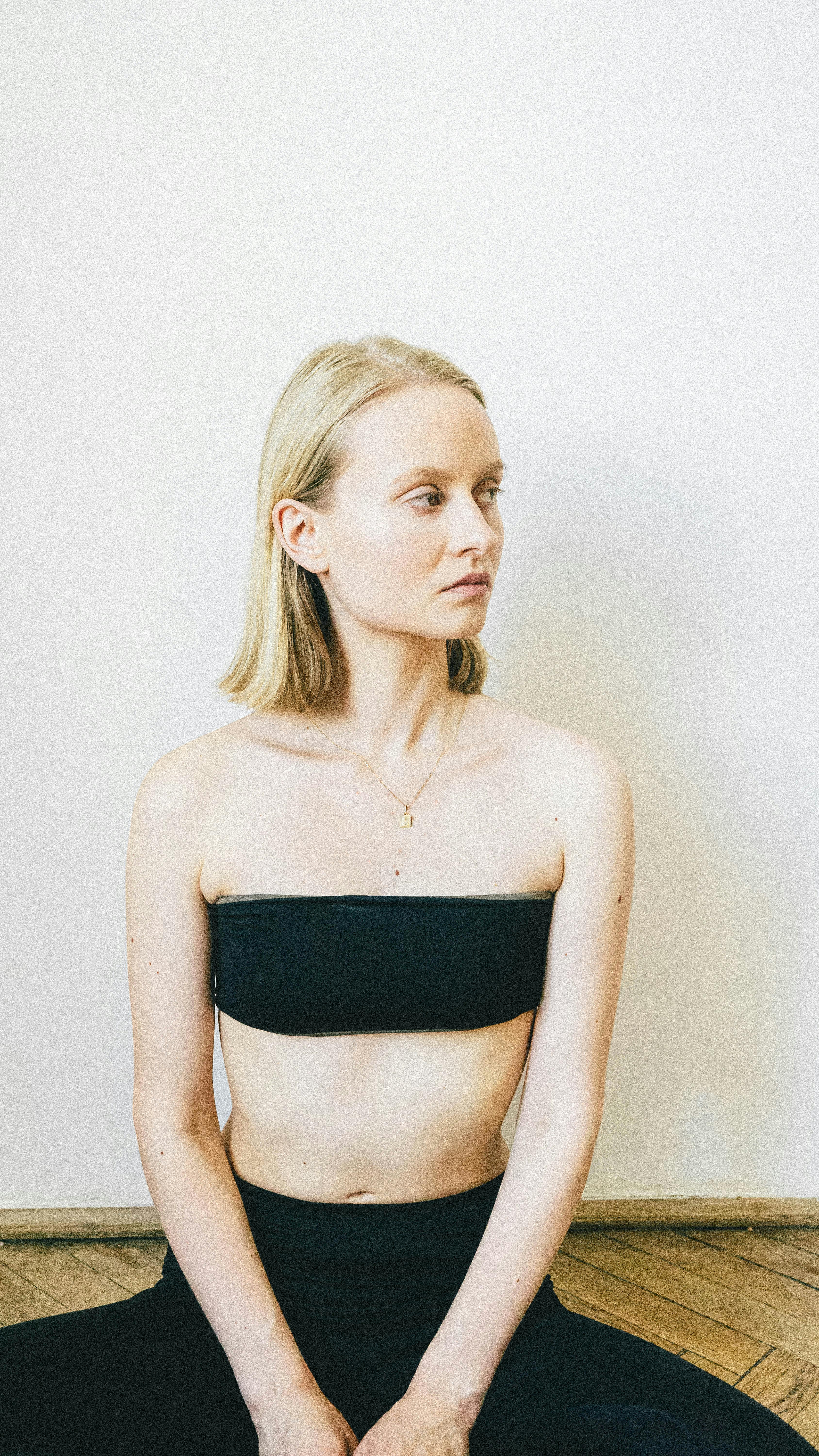 A Blonde Haired Woman in Black Tube Top Standing Near the Wooden Railing ·  Free Stock Photo