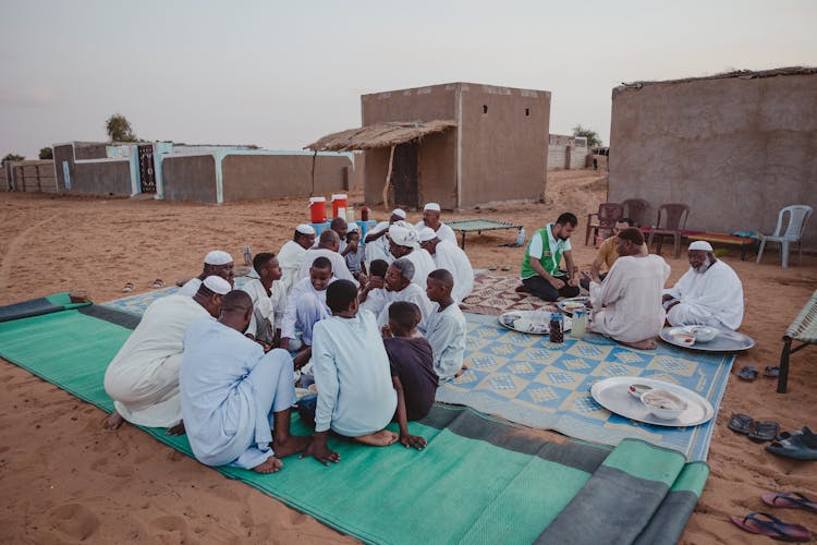 Men Eating In A Group Outdoors 