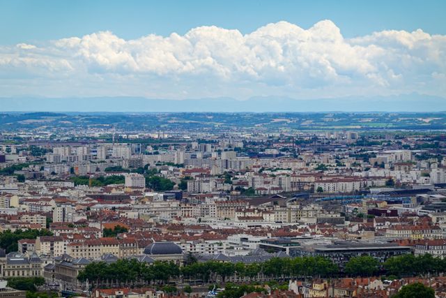 Aerial view of Lyon showcasing the sprawling urban landscape under a vibrant blue sky.