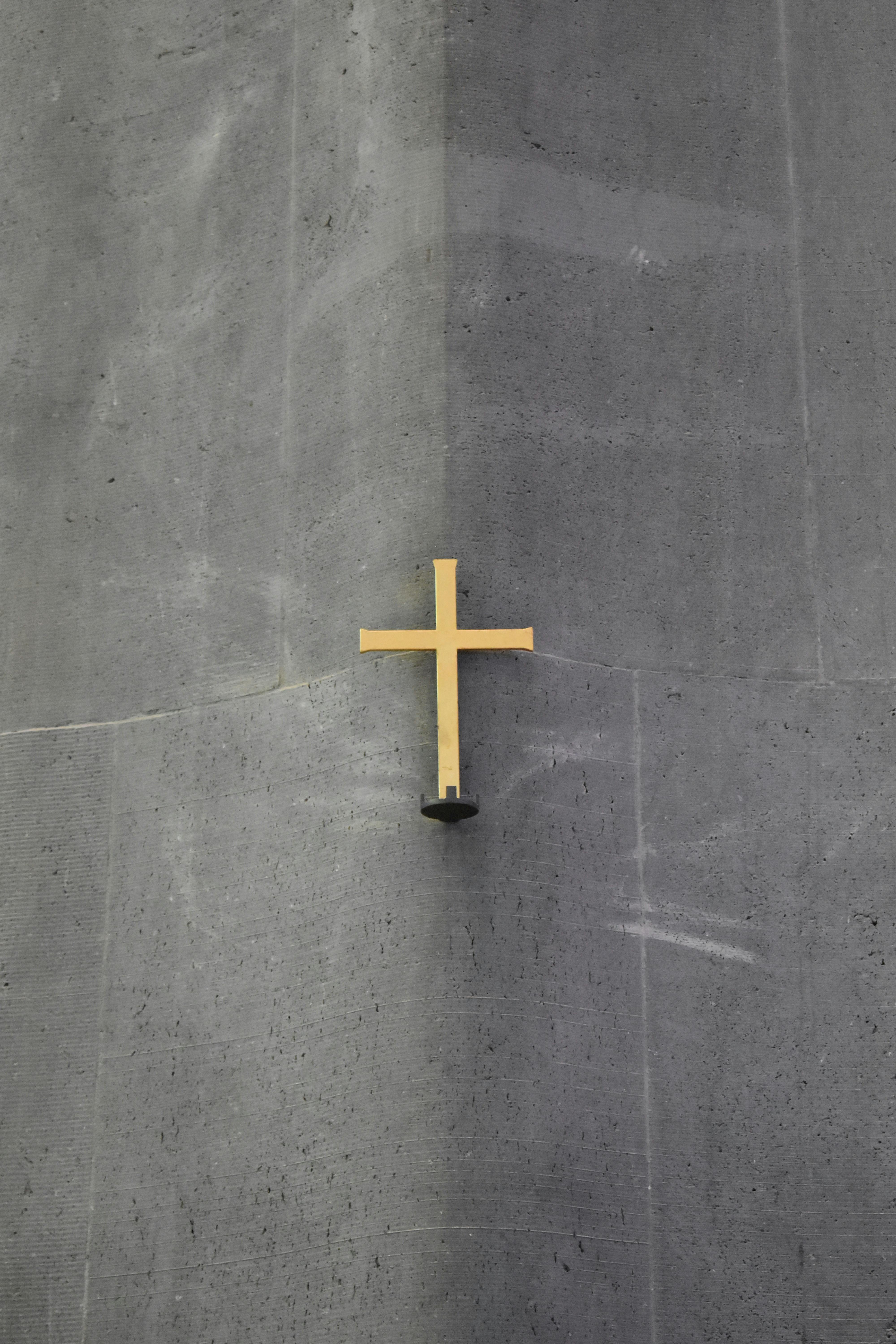 brown cross on gray concrete wall