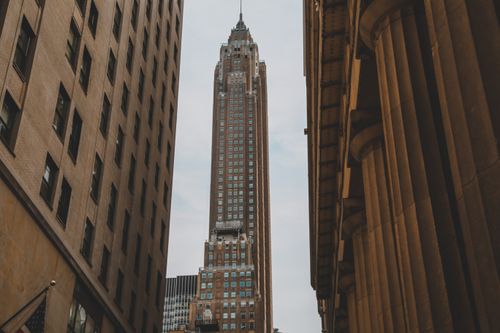 Free A soaring view of an iconic skyscraper framed by urban architecture in New York City. Stock Photo