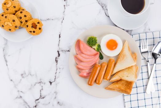 Appetizing breakfast plate with eggs, sausages, toast, and coffee for a delightful morning meal.