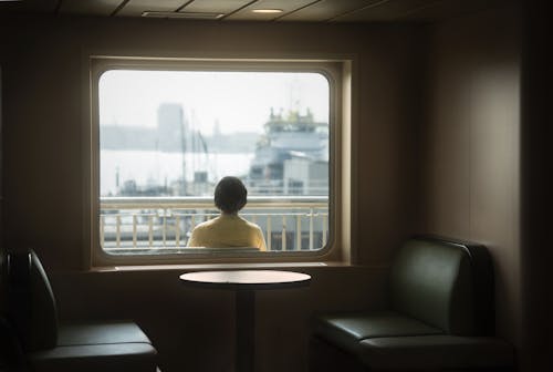 Woman Sitting behind Window