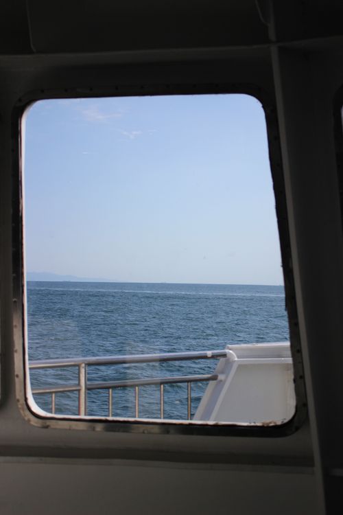 Free Ocean view through a boat window, capturing a serene horizon on a clear day. Stock Photo