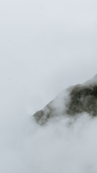 A scenic view of a foggy mountain top in the Dolomites, Italy.