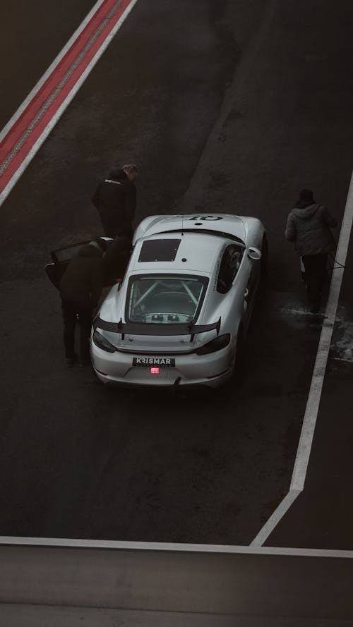 People Standing outside a Parked Sports Car
