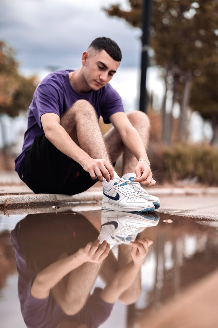 Man Tying His Nike Shoes Near The Water