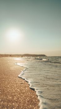 A tranquil Istanbul beach at sunset with gentle waves and a warm glow.