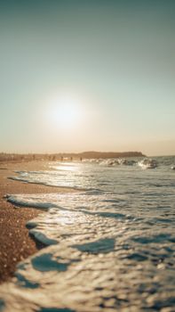 Capture of a tranquil beach with waves and a brilliant sunset, perfect for relaxation themes.