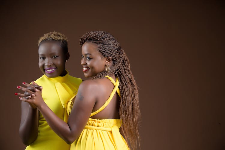 Young Beautiful Women Standing Together Smiling In Yellow Dresses