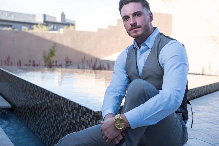 A Businessman Sitting Near The Infinity Pool